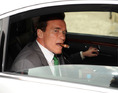 Governor of California Arnold Schwarzenegger smokes a cigar in his limousine as he leaves the CeBIT fair, America