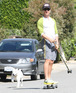 Matthew McConaughey rides on a skateboard followed by his dog.