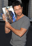 'The Ugly Truth' star Gerard Butler poses with a picture of himself in 'Nim's Island' outside his hotel in London.
